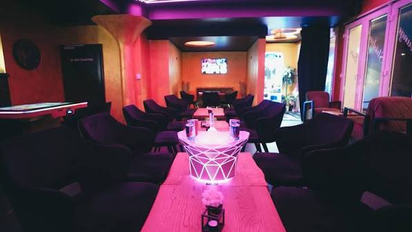 Innenraum von Habibo's mit beleuchteten Tischen und Lounge-Sitzplätzen